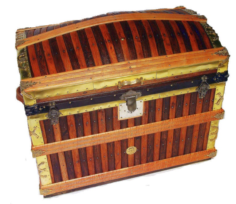 In impeccable condition, this large trunk has vertical light and dark stained oak outer slats that have been top-coated with tung oil, tiger maple fluted slats, secured by solid brass slat holds..  Bound on all edges with brass sheeting and solid