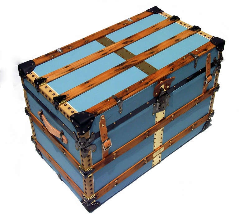 Antique personal trunk covered in baby-blue cotton canvas duck with chrome tanned leather binding.  Center front and top brass accent, leather corner guards, twin leather half-belt closures.  Oak slats, end-wrapped in brass sheet.  Original CORBIN