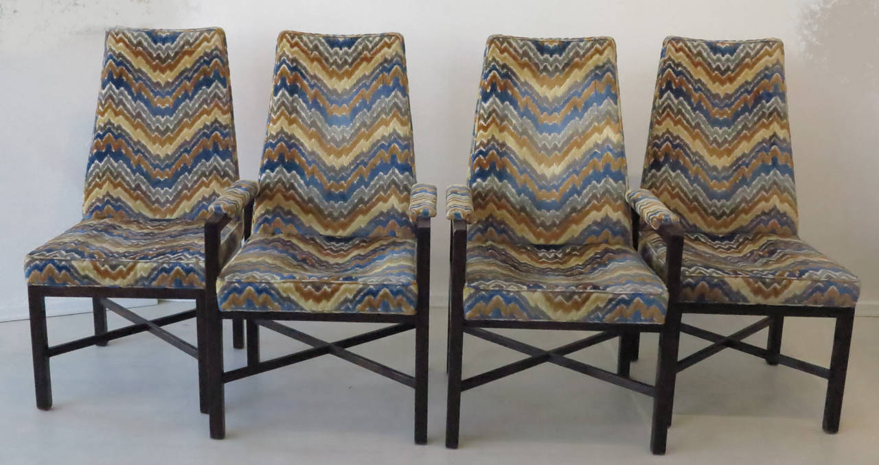 Set of four Dunbar dining chairs by Edward Wormley (two armchairs, two side chairs) each retaining their original vibrant and colorful flame stitch upholstery in very good condition. These distinctively designed and crafted chairs, with their solid