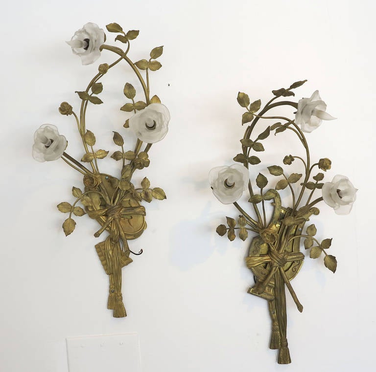 Beautifully designed pair of rose branch wall sconces skillfully detailed and crafted in heavy d'ore bronze with three (3) lovely frosted glass rose buds each containing one candelabra bulb within. The lovely, aged patina of the d'ore bronze