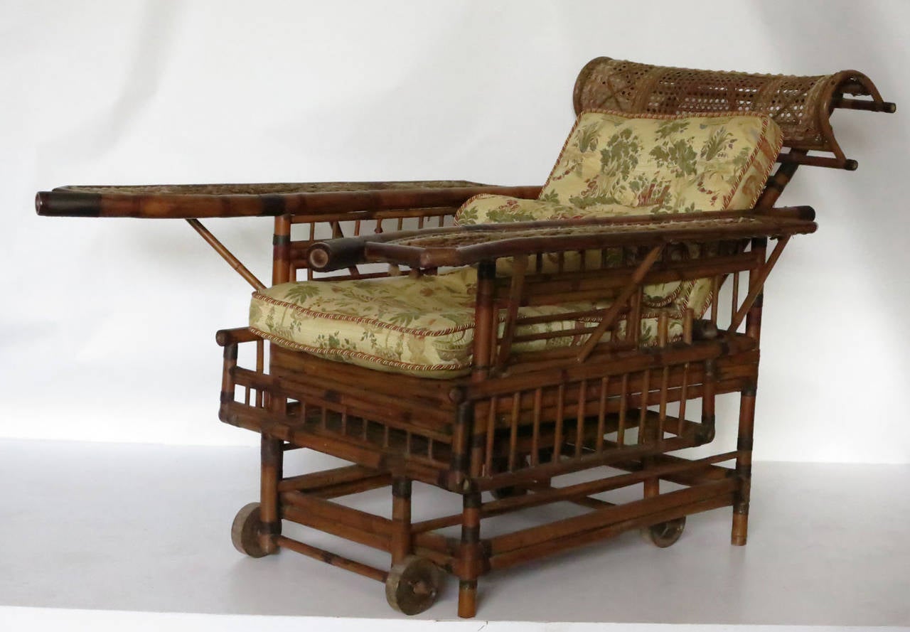 Antique bamboo Chinese plantation chair. Wide arms with cane and woven fabric. Has a roll out foot stool with an adjustable back.