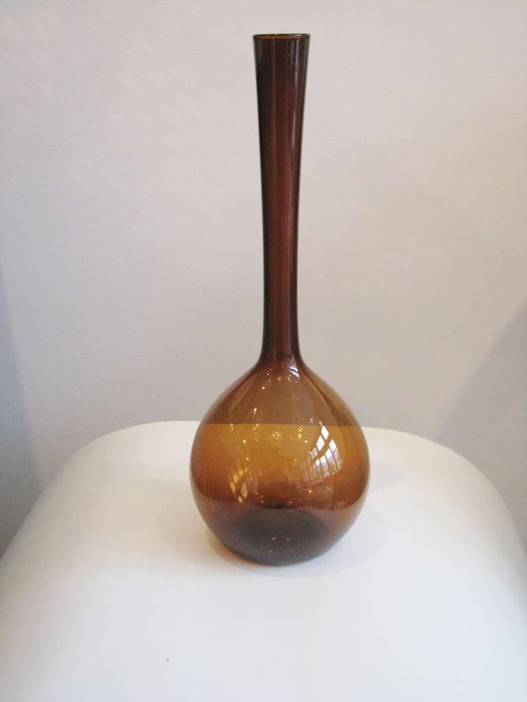 Tall bottle shaped glass vase in amber.