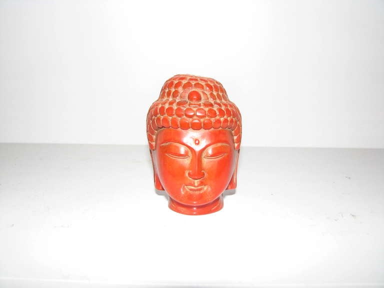 Small carved Buddha head made of red coral. No markings.