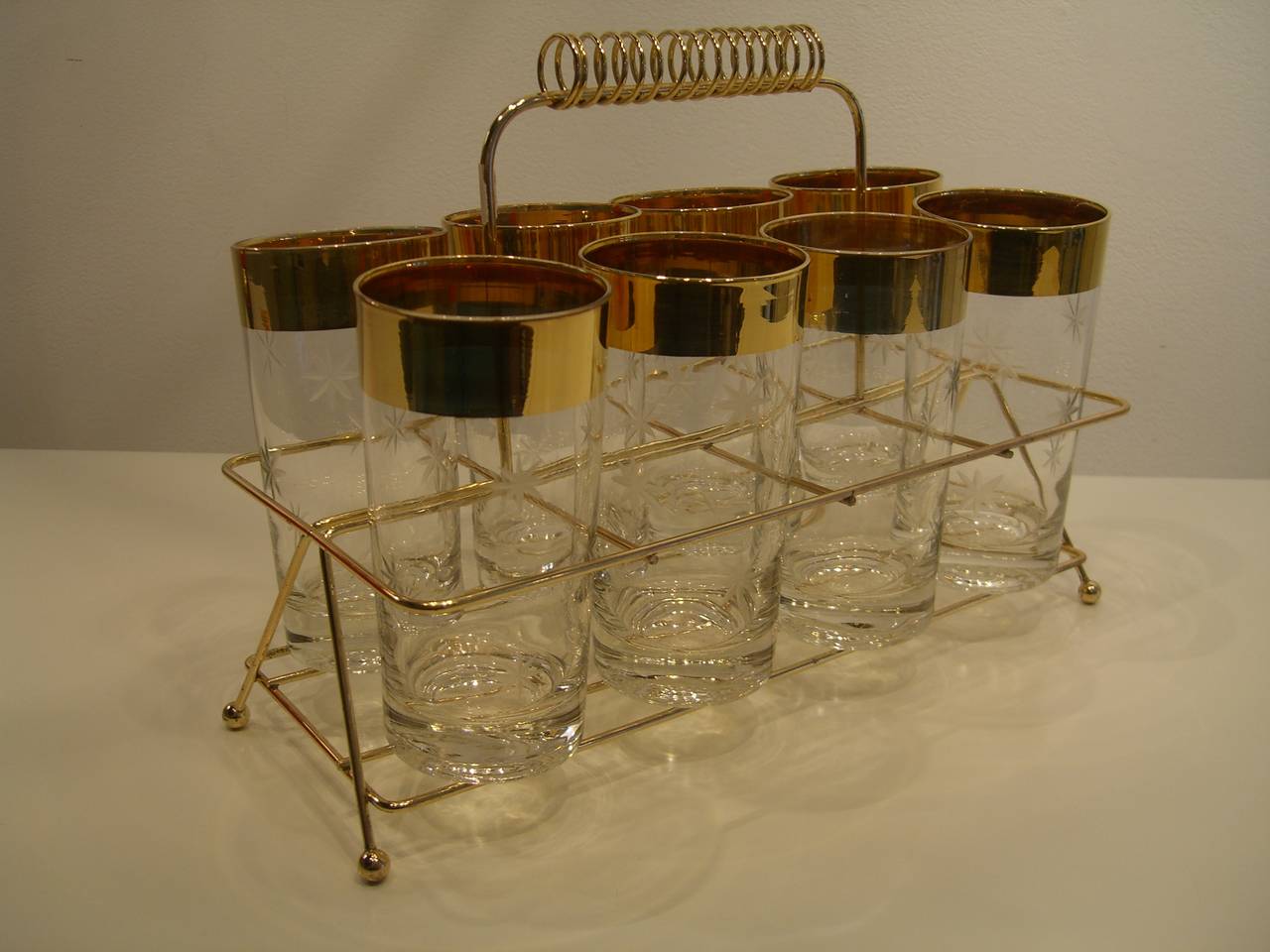 Set of eight gold rimmed highball glasses with etched stars in original holder.