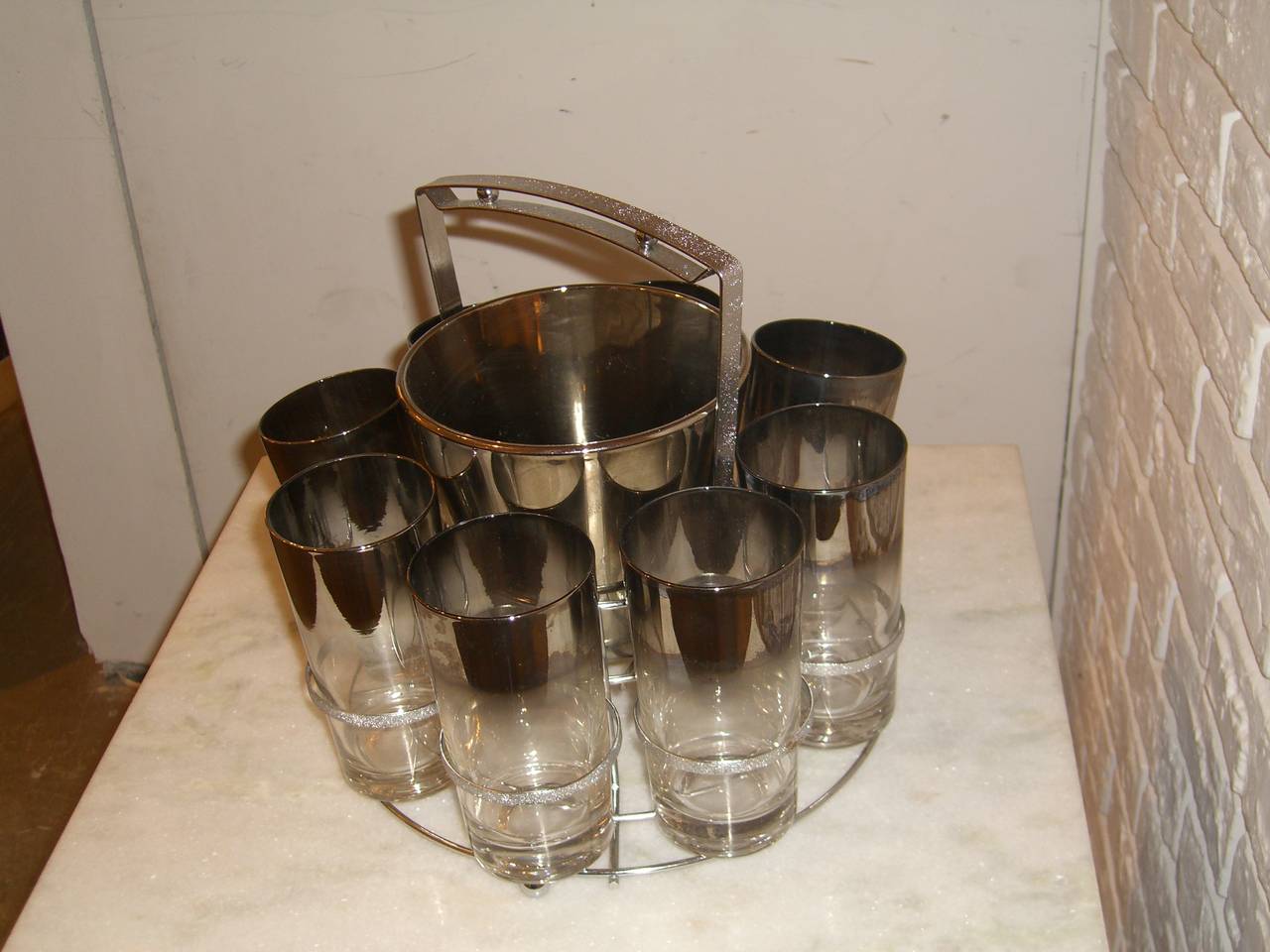 Set of eight Dorothy Thorpe highball glasses with matching ice bucket in original holder.