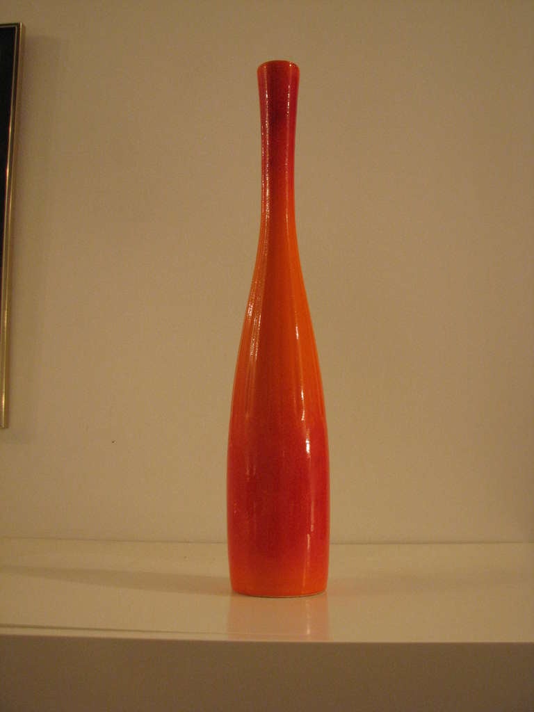 Tall bottle shaped Haeger vase in their trademarked flaming orange. Ribbing to the middle section of the vase