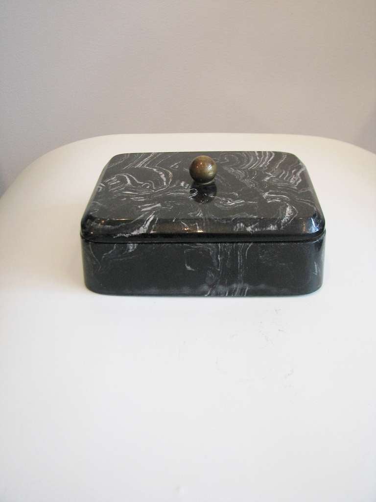 Deco style black marble box with brass ball handle on lid.