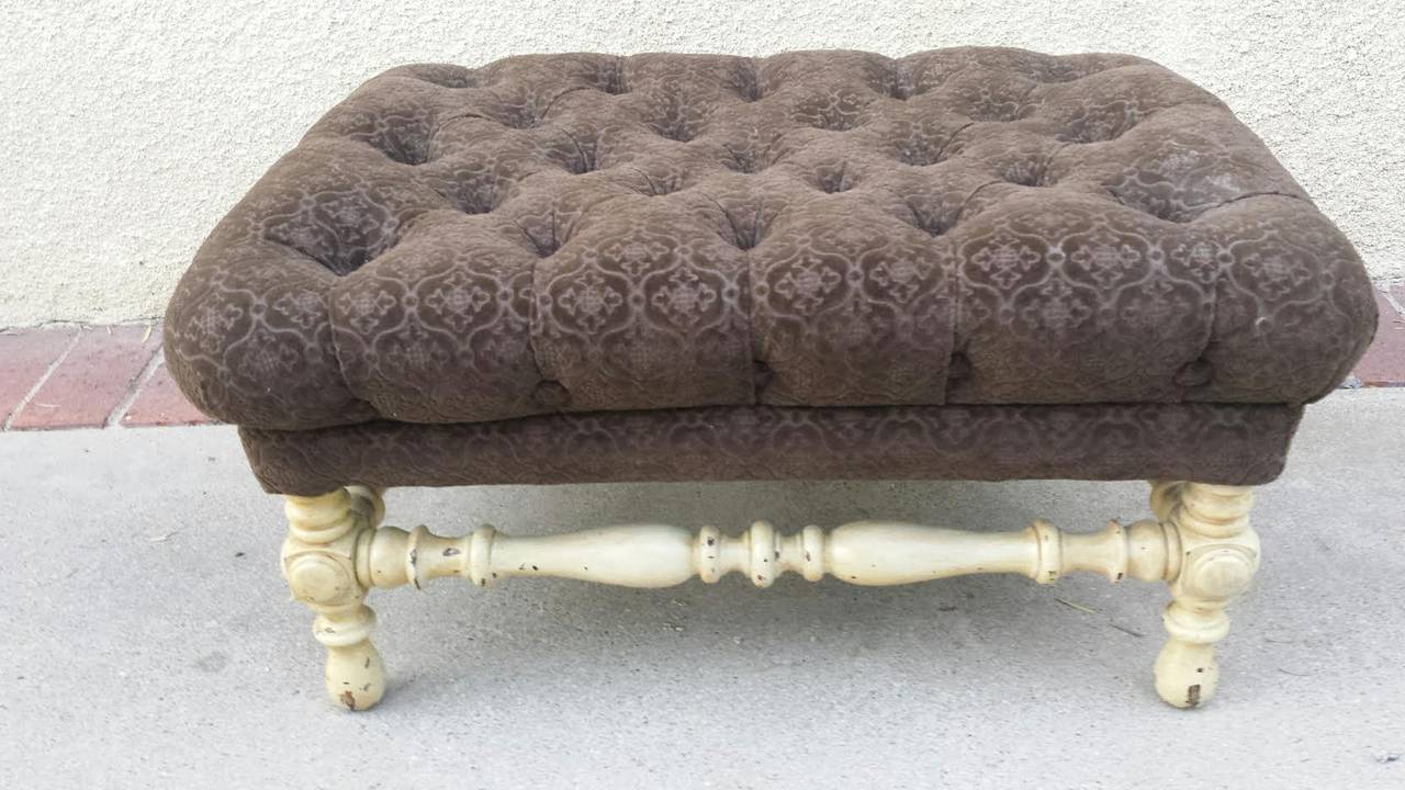 Pretty ottoman / foot stool in the french provincial style. Upholstered in brown floral patter velvet fabric and deep tufted. Sit on a solid wood frame with four legs in distressed beige / cream color.
