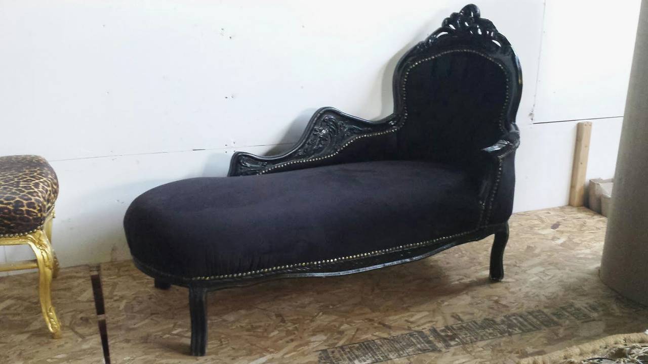Beautiful chaise longue in the French Louis XV style. Solid wood frame with hand carvings painted in black. Upholstered in black velvet fabric and deep tufted on the back. Nailhead trim.