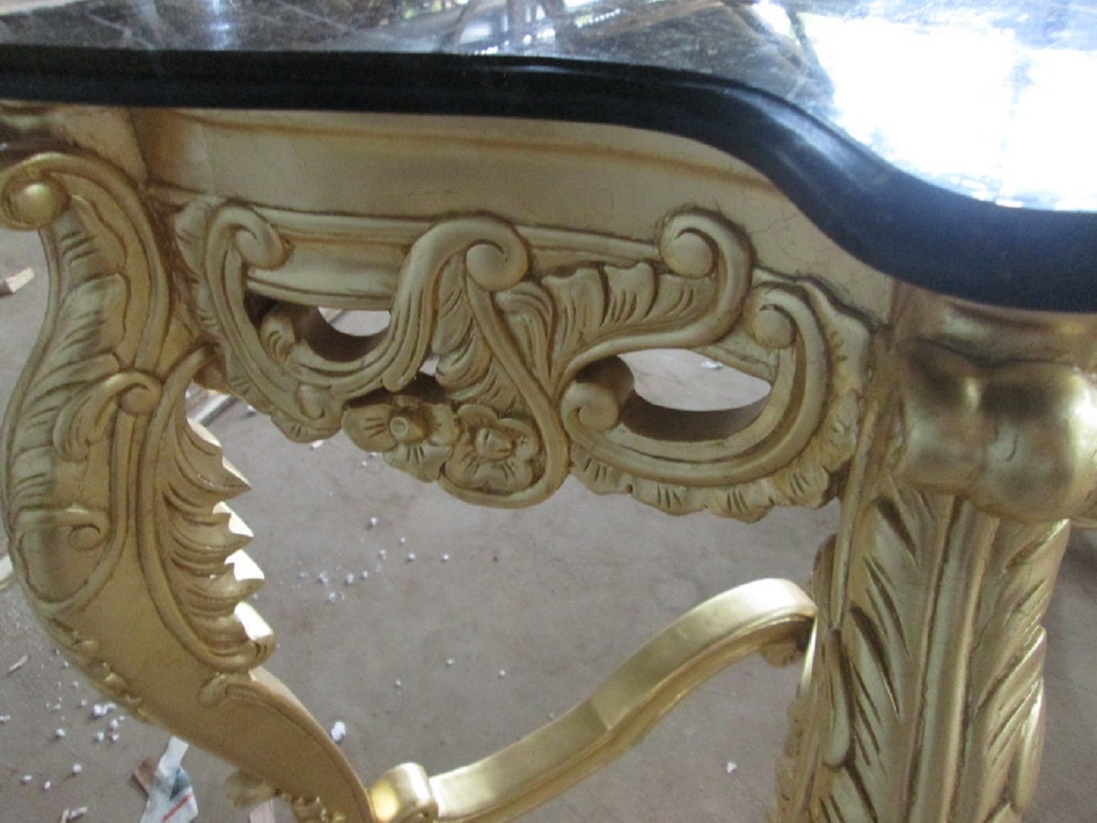 A french louis xv style console table in gold leaf finish. Black marble top.