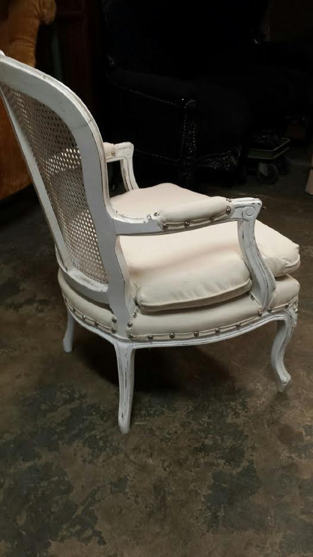 French Louis Farmhouse Chic style arm chair in white distressed finish. Newly upholstered in off white fabric with a nail heads trim.