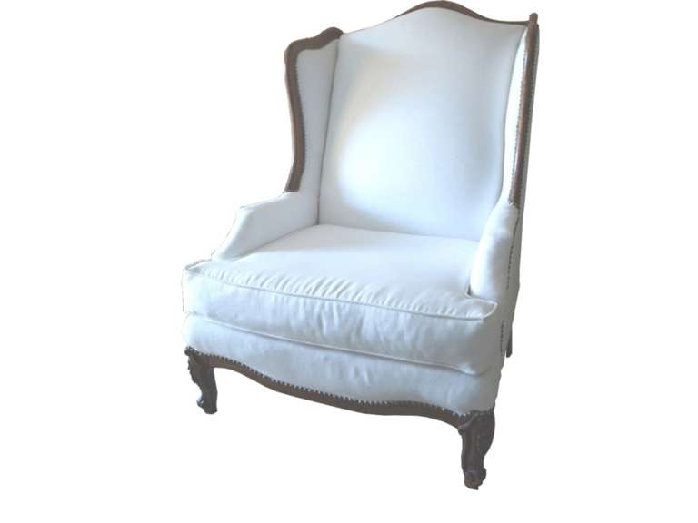 High back wing back chair newly reupholstered in white cotton fabric with nail head shown around..
In Excellent Condition and comfortable.