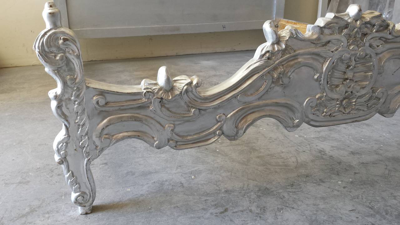 Beautiful bed with hand carvings on the foot board and headboard. The wooden frame is newly painted in silver leaf finish. 
Will fit a standard King size Mattress 76
