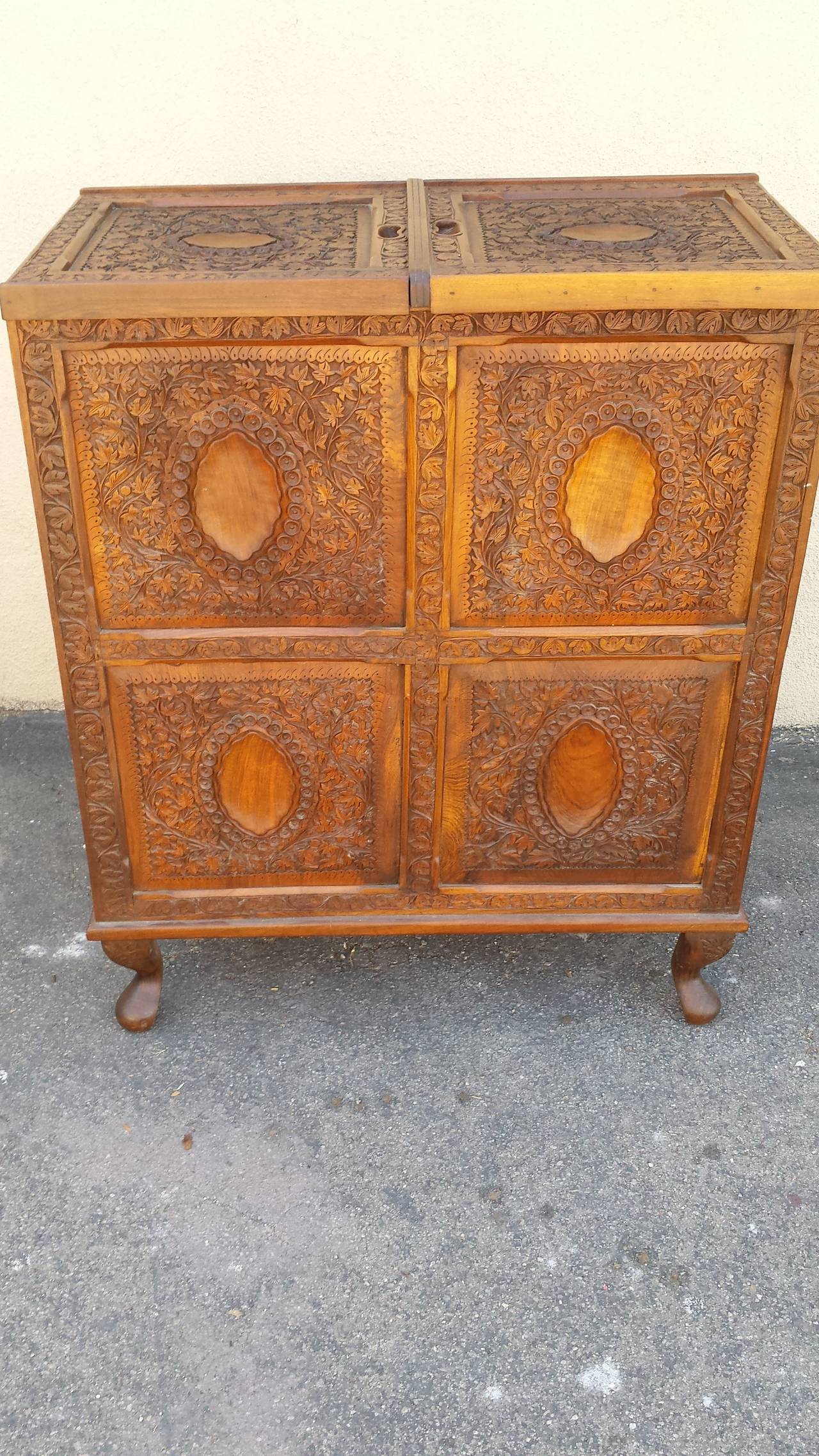 Unusual pop up bar. By opening the leaves the bar will be raised along with your glasses and bottles. Two doors on the bottom of the bar for extra storage.
The bar / cabinet carved in the back same as the front.