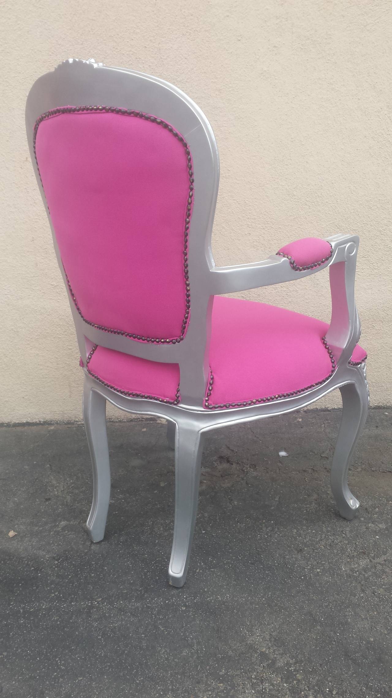 French Louis XV style  arm chairs covered in pink fabric. Deep tufted on the back. The solid mahogany frame is finished in silver with beautiful hand carvings. The arms are padded for more comfort. Nail heads trim shown.
Newly painted and