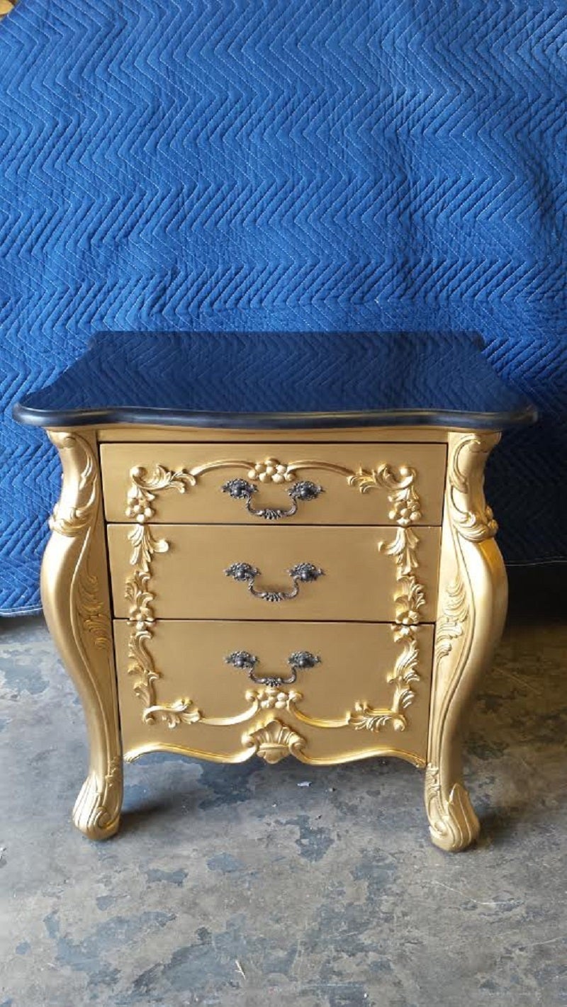 A pair of French Louis XV style 3 drawers side tables or great to use them next to your bed. The carved wood is newly painted in gold finish. The top is a black marble.

Dimension: 20