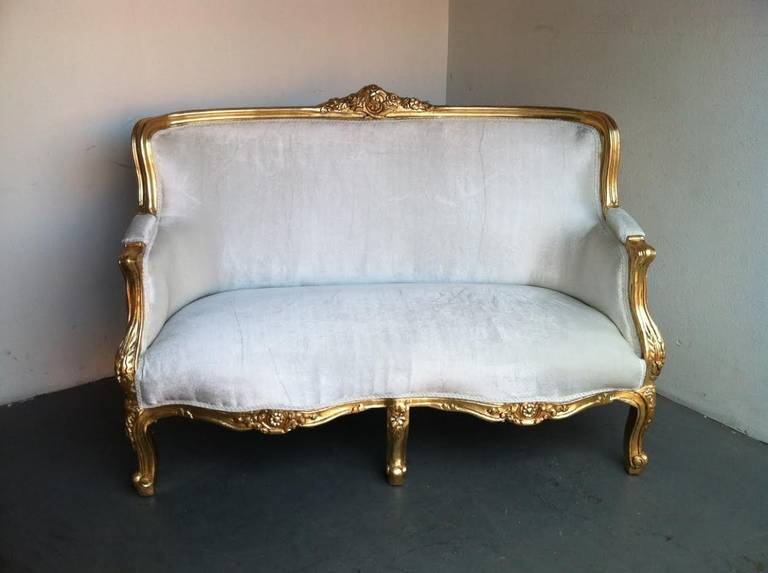Beautiful settee in French Louis XV style. Wooden frame finished in gold leaf with beautiful carved details. Newly upholstered in a grey or champagne velvet.