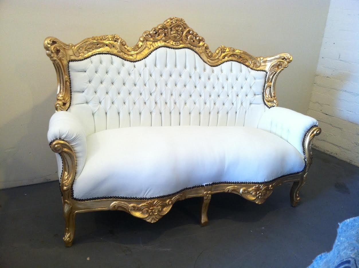 Beautiful sofa in the French Rococo Louis XV style. Newly covered in white faux leather. Carved frame in gold leaf finish. Nail heads shown.