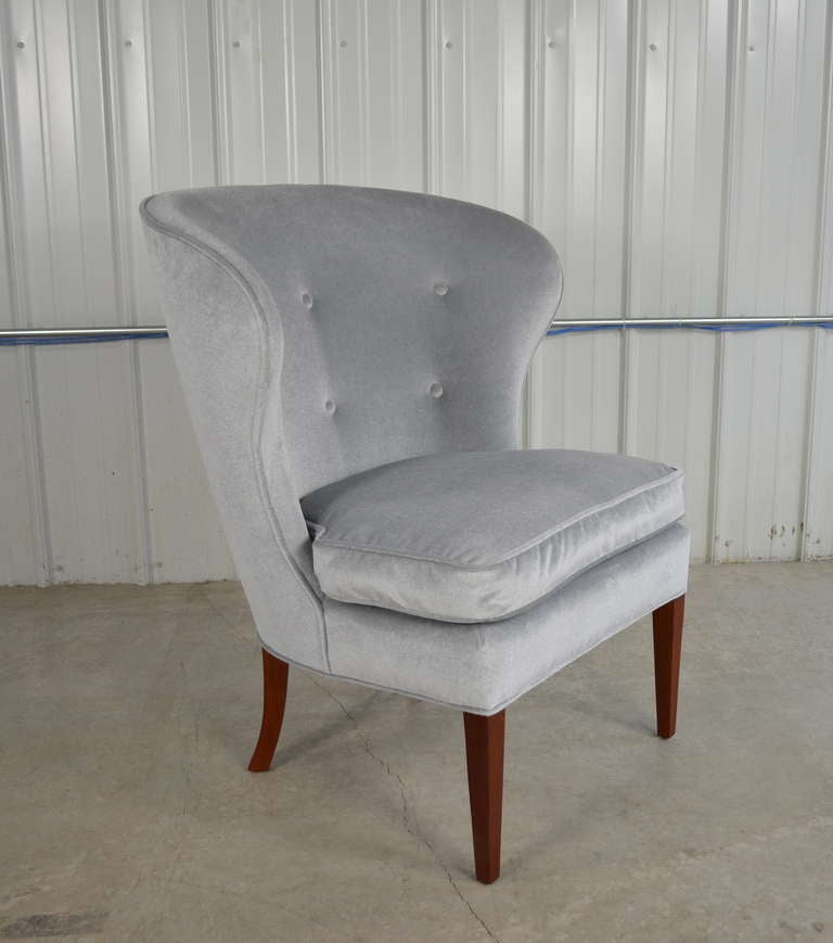 A beautiful early Scandinavian modern wingback slipper chair.  Solid mahogany legs.  Down filled seat cushion.  Tufted back.  Recovered in a silver grey/blue mohair similar to the original upholstery.