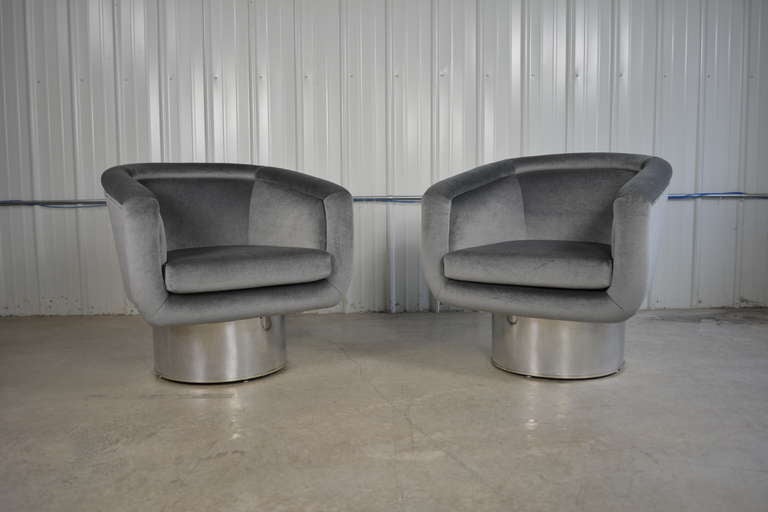 A pair of swivel lounge chairs designed by Leon Rosen for Pace.  Stainless steel swivel bases.  Newly upholstered in charcoal grey mohair.