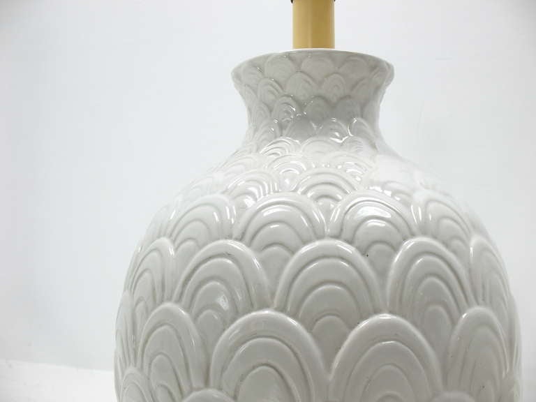 A pair of white ceramic lamps with an Asian fish scale motif.
