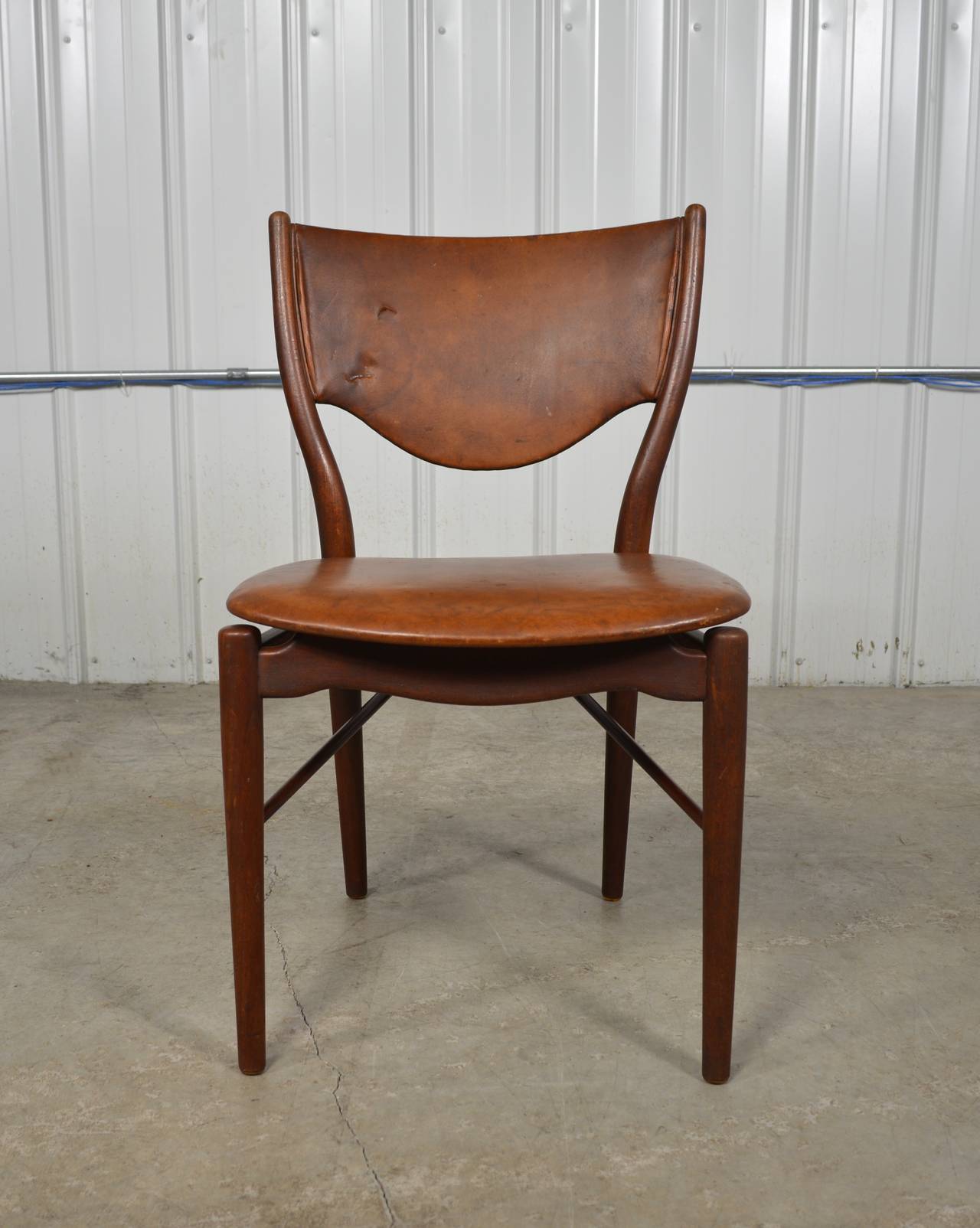 Beautifully sculpted teak and leather side chair by Finn Juhl. Original condition. Leather shows a nicely aged patina with some wear. Manufacturer's label present.