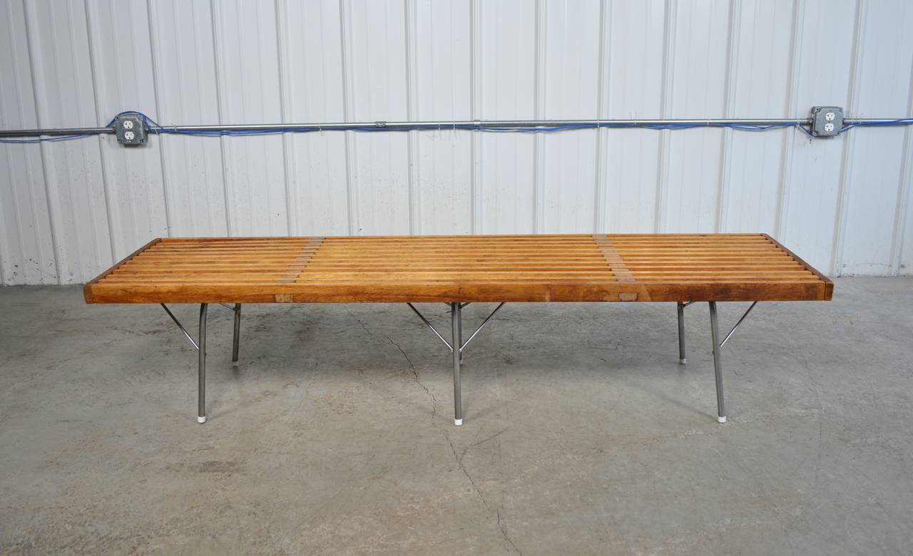 An early example of a slatted bench designed by George Nelson for Herman Miller.  Three sets of steel legs with stretchers provide support.  Partial Herman Miller tag remains.  In original condition.  Structurally solid.