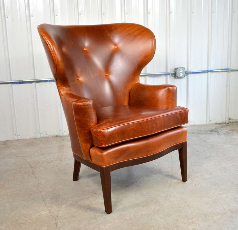 A rare early wingback chair by Edward Wormley for Dunbar in chestnut leather.  Nicely curved mahogany apron and legs.  Newly restored