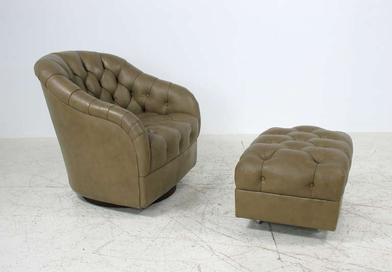 A swivel lounge chair and ottoman in leather by Ward Bennett for Brickel.  Deep tufting on back and seat of chair and ottoman.  Round swivel base on chair.  Ottoman on casters.  Labeled.  Ottoman measures 27