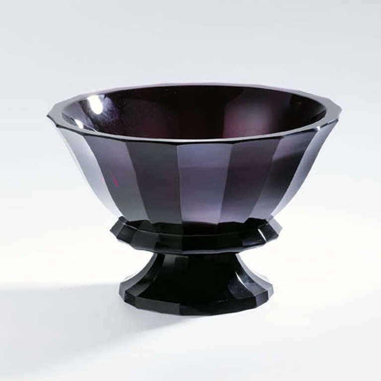 Mounted Bowl, 1915-19
Design by Josef Hoffmann, manufactured by Meyr´s Neffe, Adolf, for the Wiener Werkstätte
Violet glass, coloured paste, sides decorated with eighteen sections set off against one another in broad cuts
Mark: WW
H 17.2 cm, D