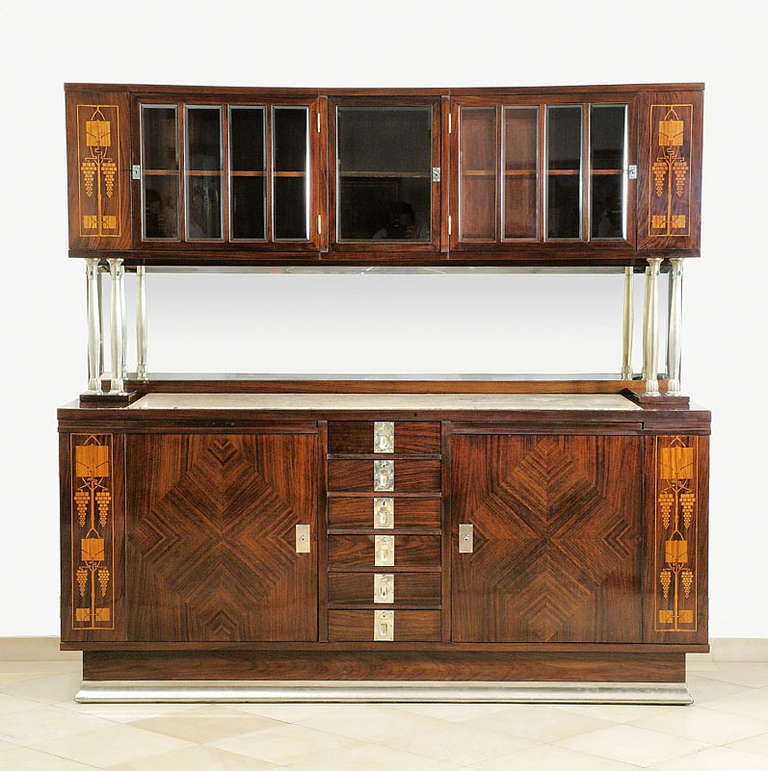 Rare sideboard, designed by August Ungethüm, ca. 1905
Macassar-ebony, marquetry in lemon wood, bevelled cut glass, columns with glasscabochons, white metal fittings, marble tops
H 192 cm, W 199 cm, D 68 cm (lower part), D 41 cm (upper