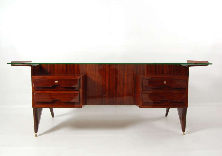 Rosewood construction with glass top, two locking drawers; brass fittings and feet. Manufactured by Dassi mobili Moderni Lissone