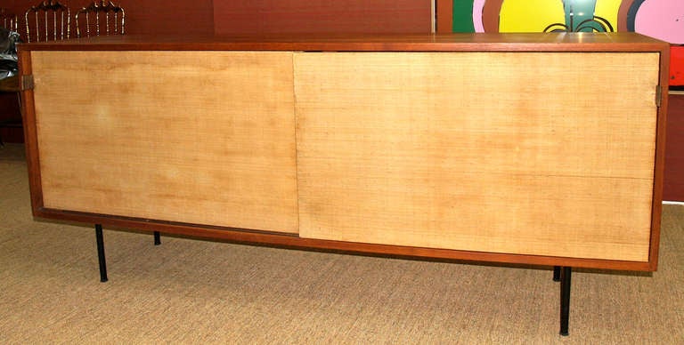 Knoll, early  50ies
72 w x 18.5 d x 30 h inches
birch, grass cloth, oak, enameled steel, leather

Two sliding doors with caned fronts reveal white lacquer interior with adjustable shelves. Signed with a factory label. Literature: Knoll Index of