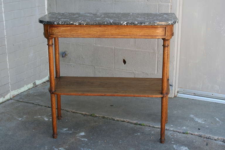 This hand pegged and turned console table has a lower shelf and its original Saint Anne marble top, c. 1880.  This table's scale would make it work beautifully as a small entry piece, sofa table, or side table.