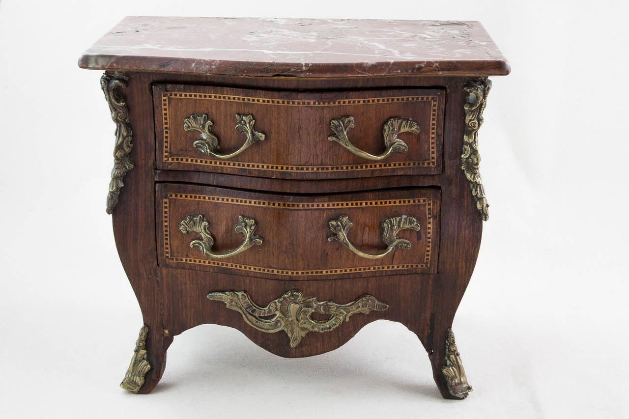 This miniature chest in the Louis XV style is  called a meuble de maitrise in French.  It was a model for a full sized chest created as a masterwork by a cabinetmaker's apprentice to prove mastery of his craft. This unusually detailed example
