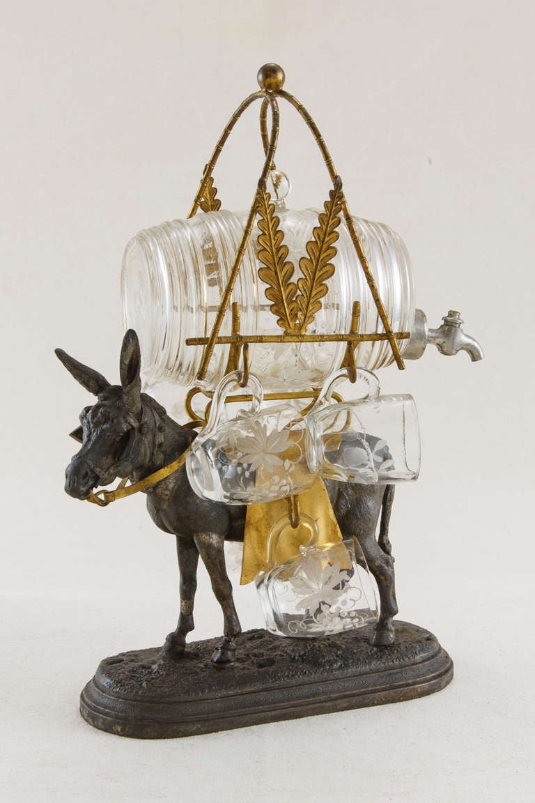 This Napoleon III cave à liqueur, or liquor caddy, features a Regule donkey with gilt bronze saddle carrying a hand painted crystal barrel with stopper and six hand painted glasses. c. 1860