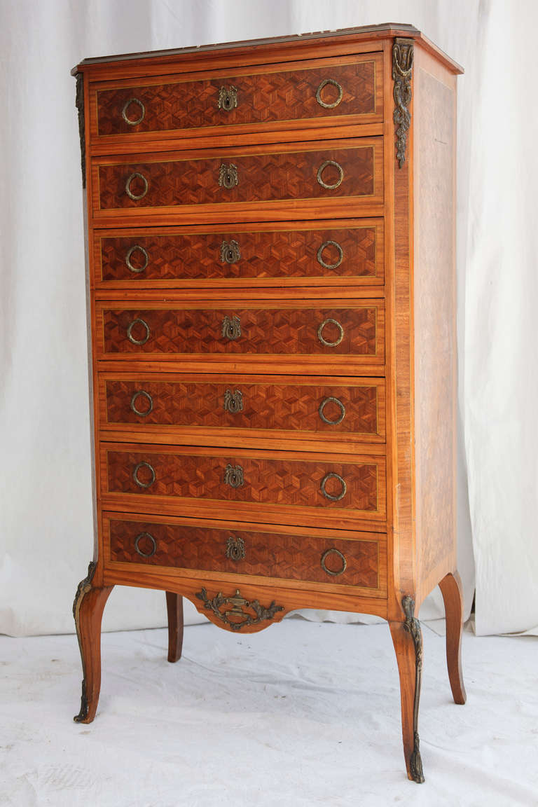 This exquisitely detailed mahogany and rosewood marquetry semainier chest has its original rouge marble top, bronze gallery, and ormolu sabots. At just 17