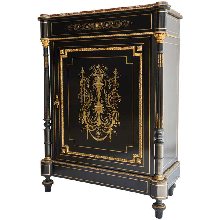 This rare Napoleon III period ebonized pearwood cabinet features intricate bronze and mother-of-pearl inlaid neoclassical motif, with its original rouge marble top. The fluted columns are detailed with gilt bronze ormolu, and the large single door