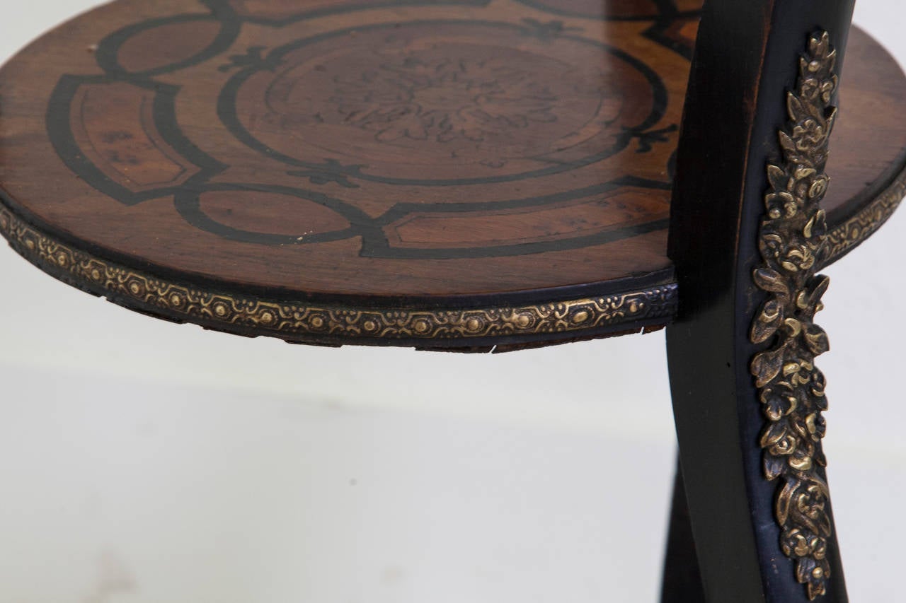 This Napoleon III marquetry jardinière features geometric and floral inlay of walnut, rosewood, lemon wood, ebony and sycamore. Its delicately carved legs are adorned with elaborate ormolu and feature a bronze greyhound at the top of each leg. A