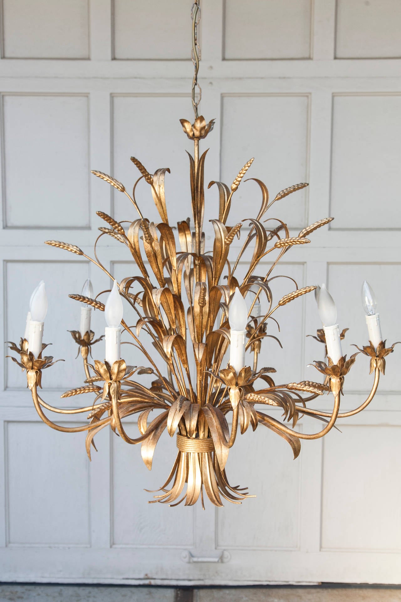 This Classic sheath of wheat design chandelier features a spray of bound wheat and leaves with floral petals extending in ten arms to hold candelabra lights. This warm and grand chandelier will enhance both old world and modern environments.