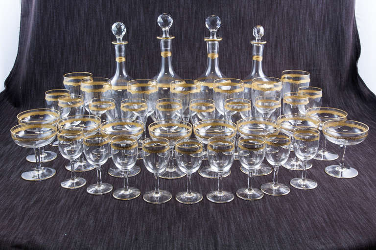Set of crystal service with gold trim, c. 1920. Includes four carafes and stoppers, ten champagne flutes, ten wine glasses, nine port glasses, and seven water goblets. Forty pieces. Found near Paris.
