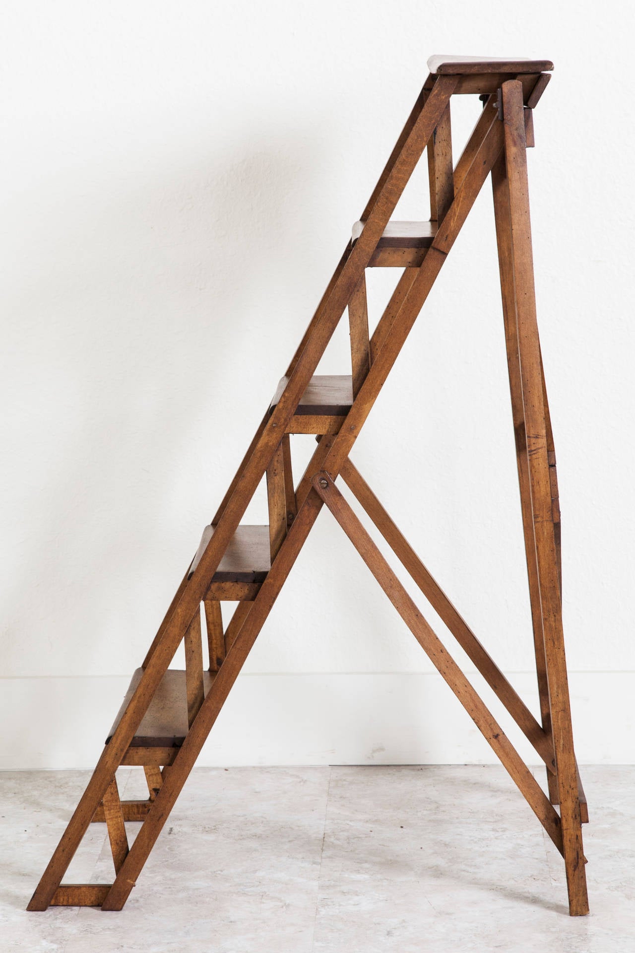 A handsome addition to any space with hard to reach shelving, this artisan made beechwood ladder was originally used in a French library. Although this piece displays beautifully as decor, it remains sturdy enough for daily use as a ladder. C. 1910.