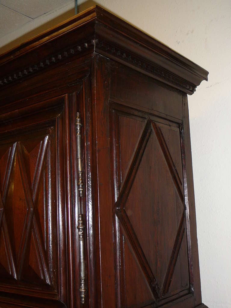 Louis XIII period diamond point four door armoire with bun feet. Hand hewn and hand carved walnut with upper and lower cabinets and two central drawers. Seventeenth century chateau piece from the Burgundy region of France.