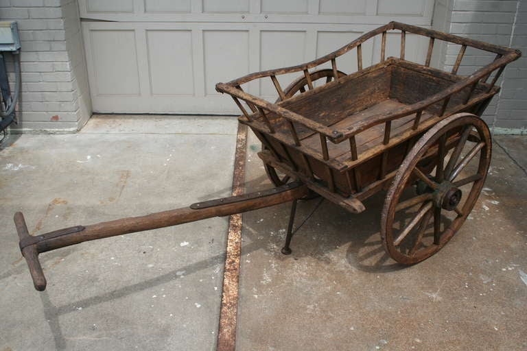 Early 19th century market cart. This artisan-made wooden cart with iron rimmed wheels was originally used to carry vegetables to sell at market. It was recently discovered in its well-preserved state in a barn in Normandy, France.