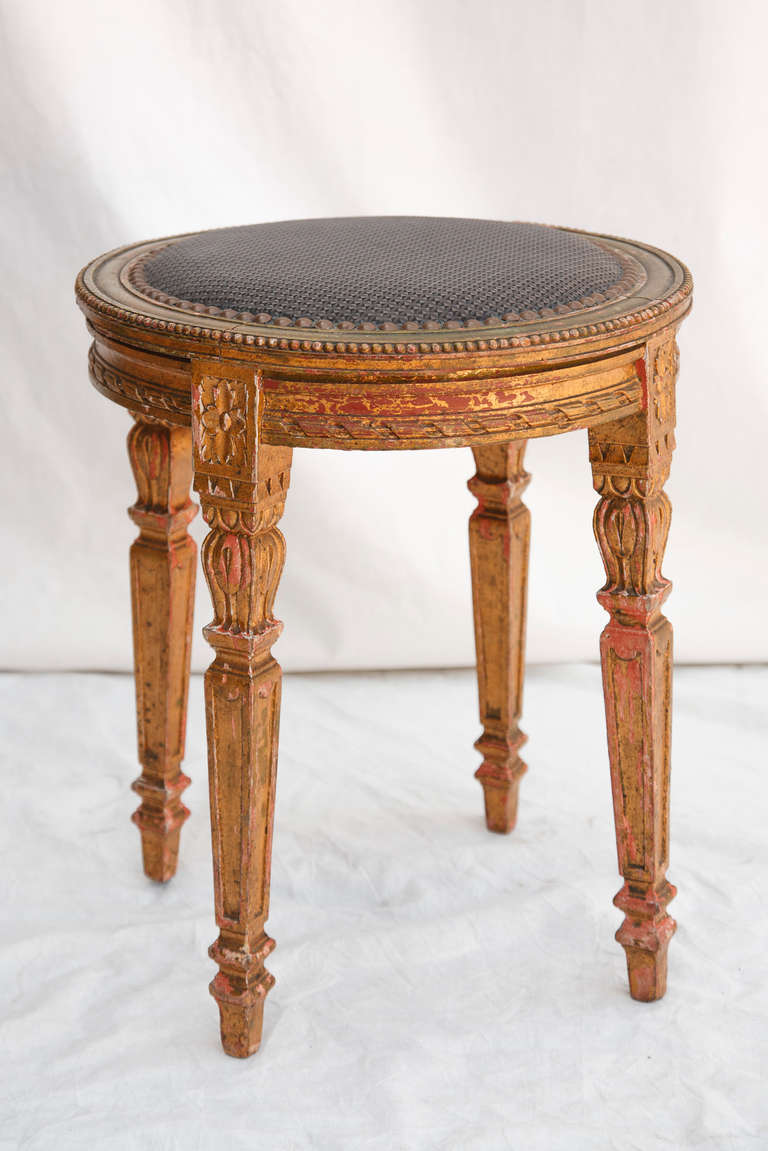 This nineteenth century hand carved gilt wood vanity stool in the Louis XVI style boasts a beautifully aged patina while creating an elegant statement in a powder bath or dressing room. Its sturdiness makes it a functional piece as well.