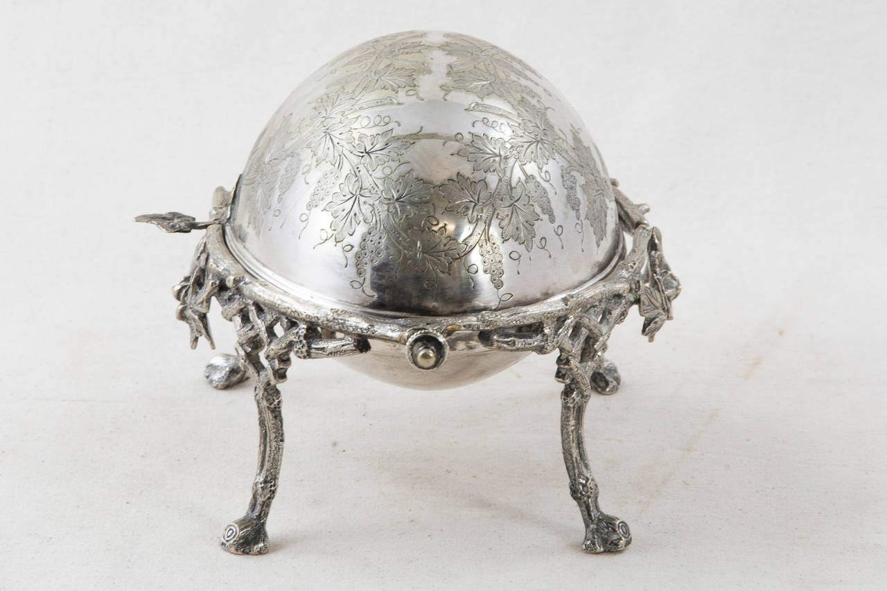 Exquisite rose, vine, and grape motifs envelope this engraved sterling silver caviar dish. A single silver leaf is the handle that opens its smoothly gliding swivel lid. A Fine presentation piece from an era which defined elegant dining, its history