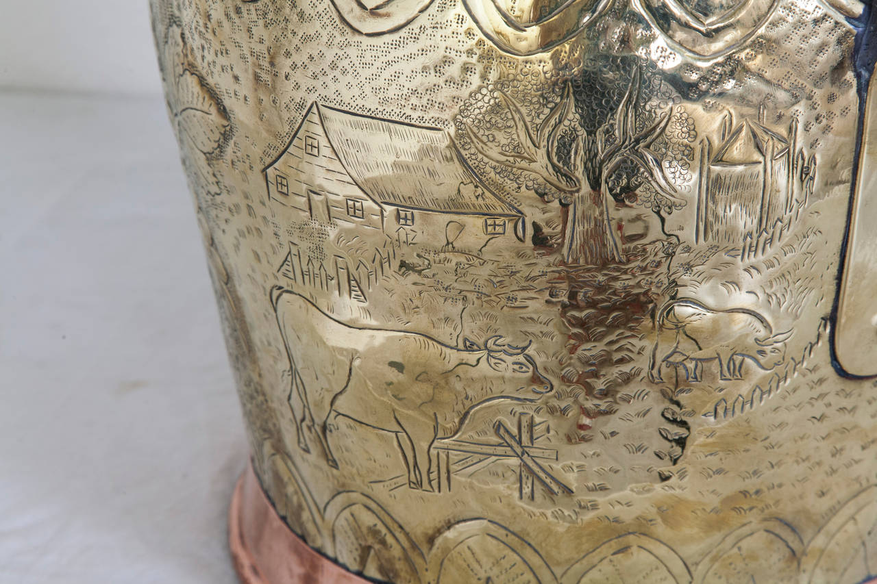 At nearly two feet in height, this impressive large-scale milk vessel is made of hand-hammered repoussé copper and brass. Created in the mid-19th century by artisans in Alsace, this piece features an ornate pastoral scene with grapevines, cows and
