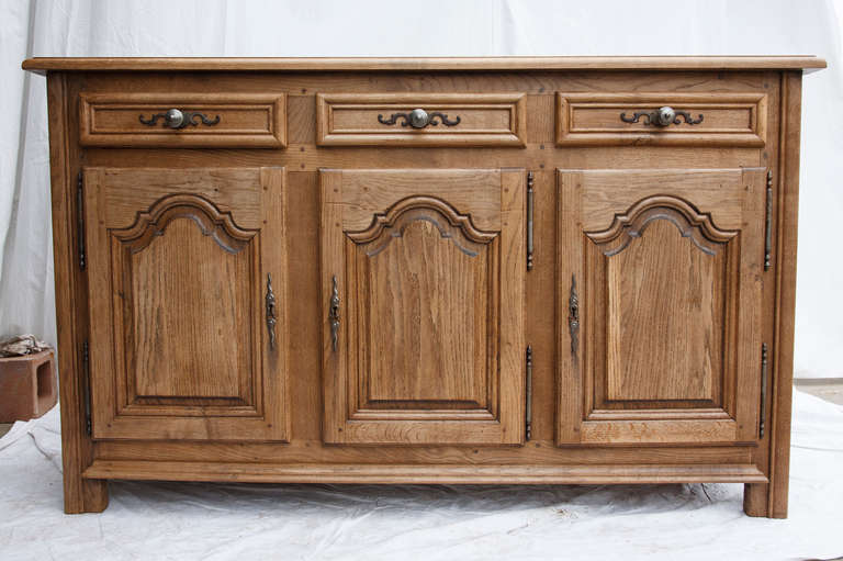 This c. 1900 hand hewn, hand pegged washed oak Louis XIV style enfilade from Normandy, France, features three raised paneled doors with hand carved beveled edges and original iron hardware.