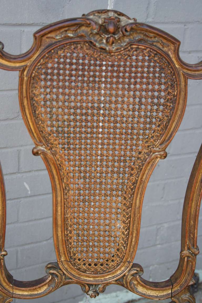 This hand carved nineteenth century gilt wood Louis XV chair boasts its original caned back in pristine condition.  Its feminine curved lines and naturally aged gilding would make an elegant statement in a powder bath, vanity, or paired with a