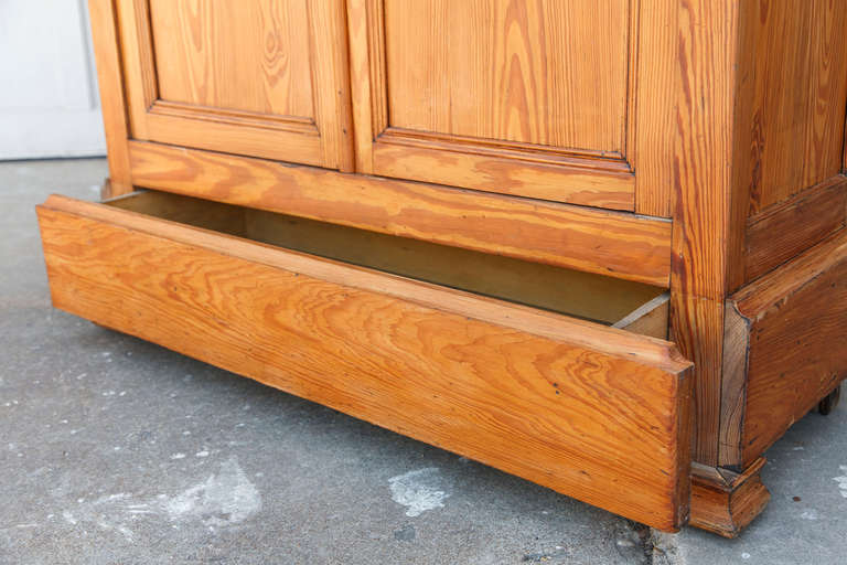 This late 19th century Louis Philippe pitch pine bibliothèque or bookcase was originally used in a seed shop in Toulouse, France.  With four adjustable  interior shelves, its original antique hand blown glass panes will beautifully showcase